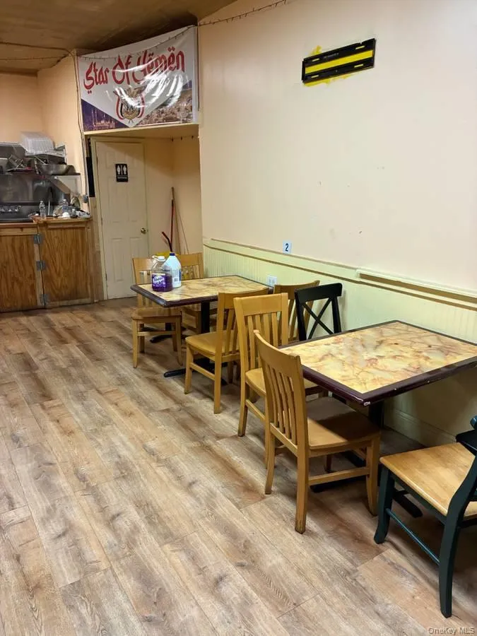 Dining room with a wainscoted wall and light wood-style flooring Dining room with a wainscoted wall and light wood-style flooring