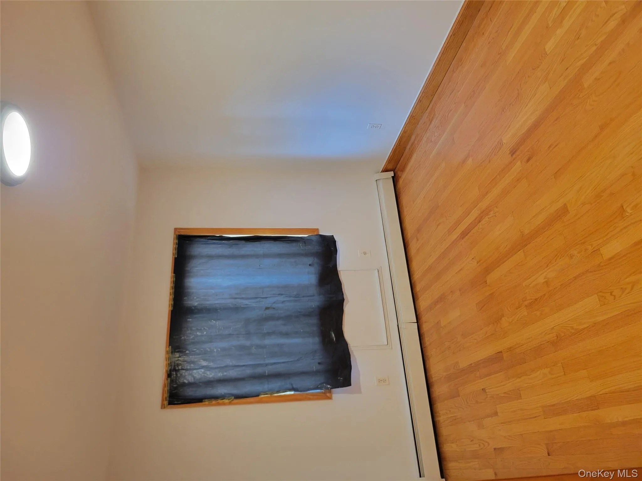 Unfurnished room featuring baseboard heating and wood finished floors Unfurnished room featuring baseboard heating and wood finished floors