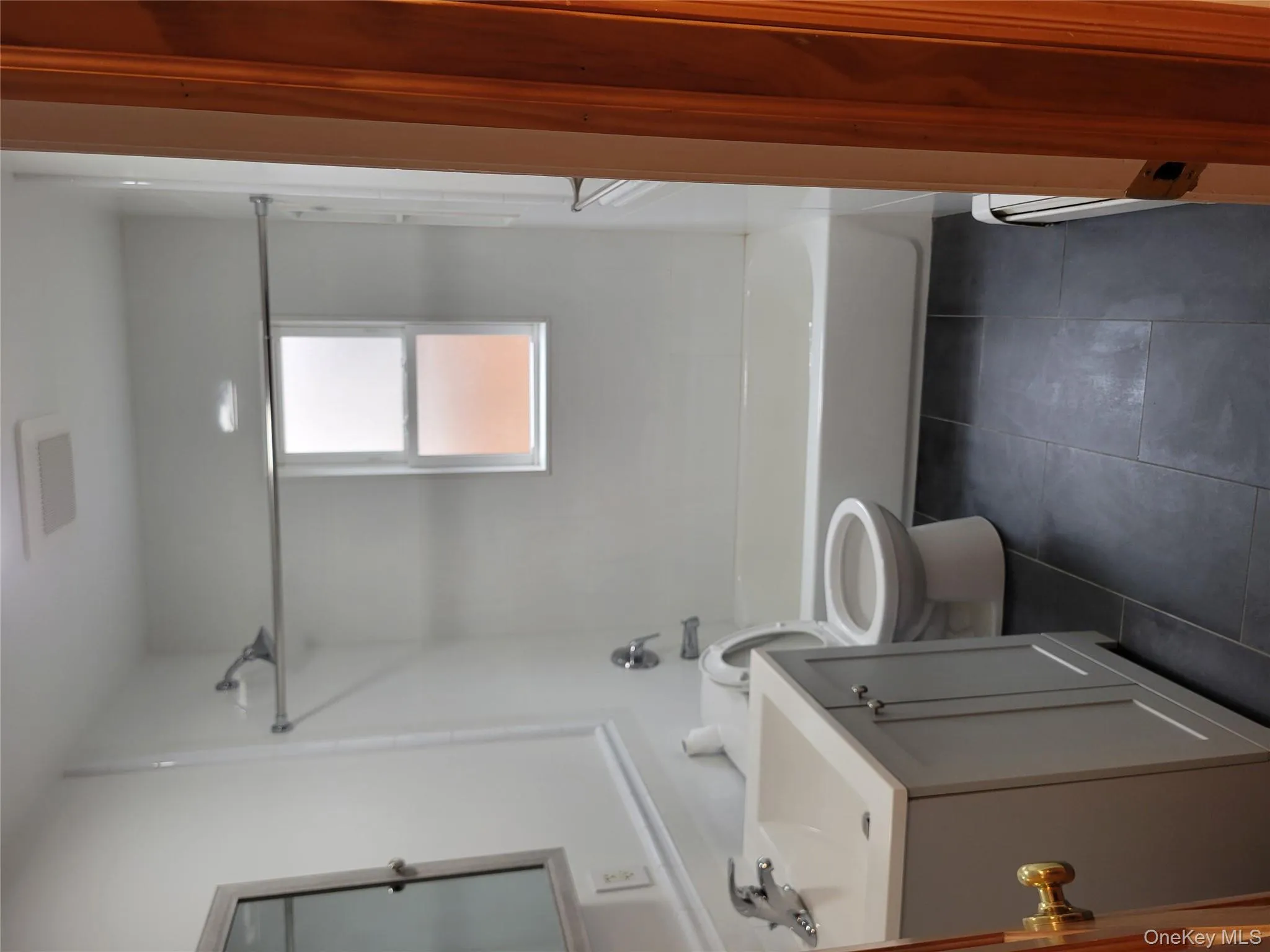 Full bath with vanity, bathtub / shower combination, dark tile patterned floors, and baseboard heating Full bath with vanity, bathtub / shower combination, dark tile patterned floors, and baseboard heating