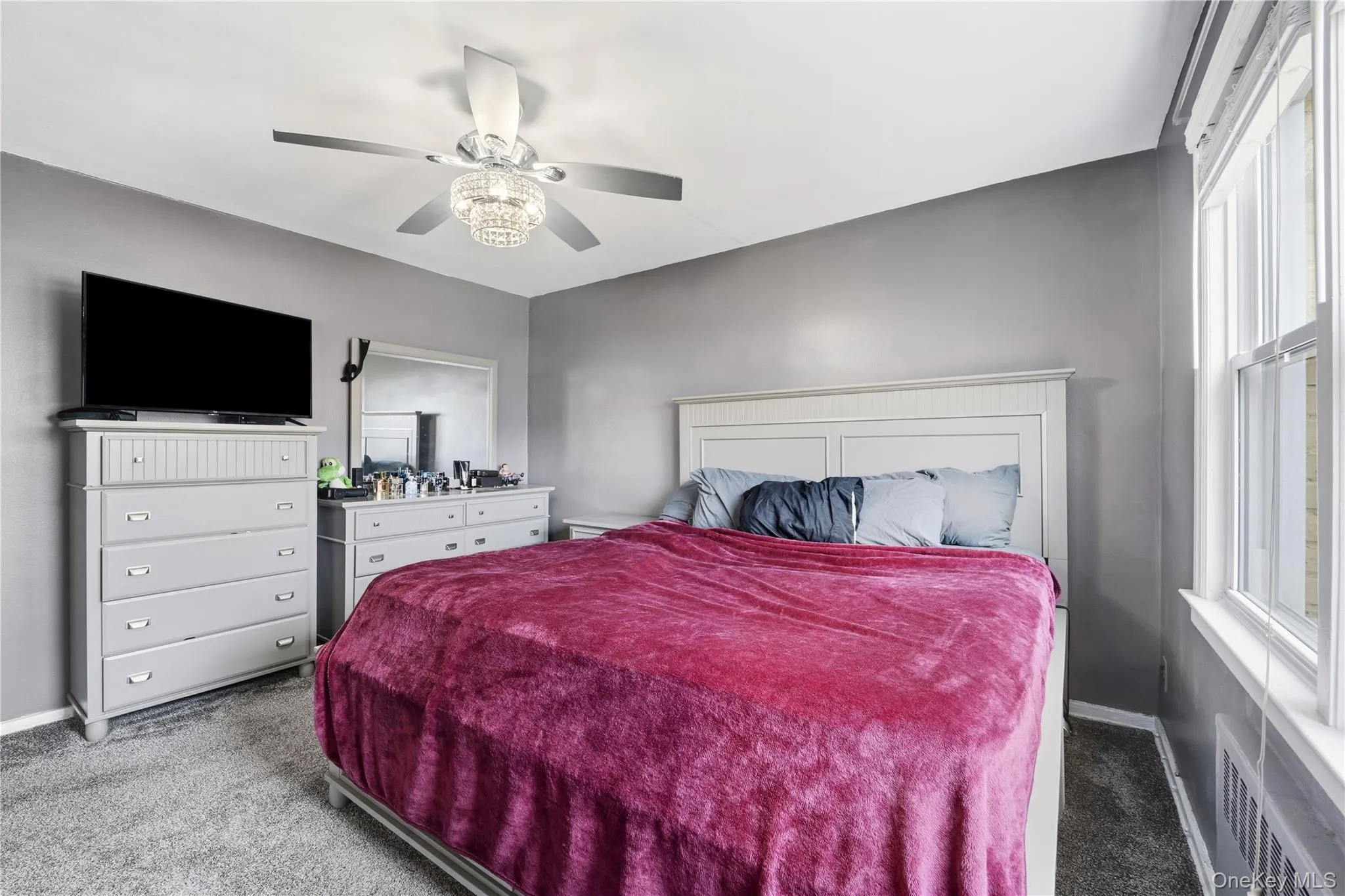 Carpeted bedroom featuring ceiling fan and baseboards Carpeted bedroom featuring ceiling fan and baseboards
