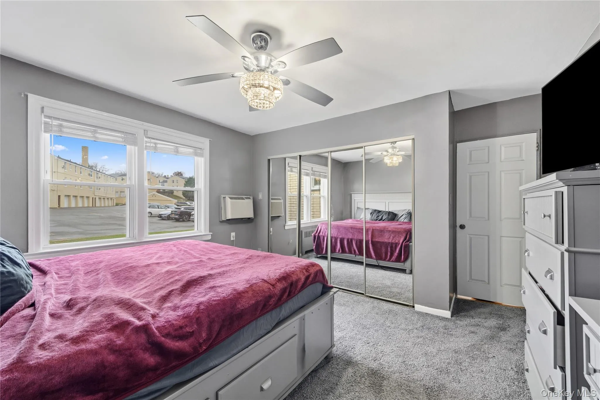 Bedroom with multiple windows, light carpet, a closet, and a ceiling fan Bedroom with multiple windows, light carpet, a closet, and a ceiling fan