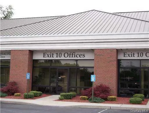 Commercial building with a standing seam metal roof, brick facade, and a prominent glass storefront Commercial building with a standing seam metal roof, brick facade, and a prominent glass storefront