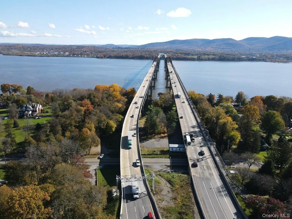 Elevated highway bridge spanning a wide body of water, with distant mountains forming a natural backdrop Elevated highway bridge spanning a wide body of water, with distant mountains forming a natural backdrop