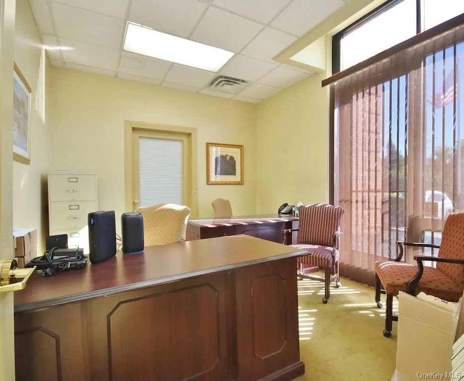 Office space featuring a drop ceiling and plenty of natural light Office space featuring a drop ceiling and plenty of natural light