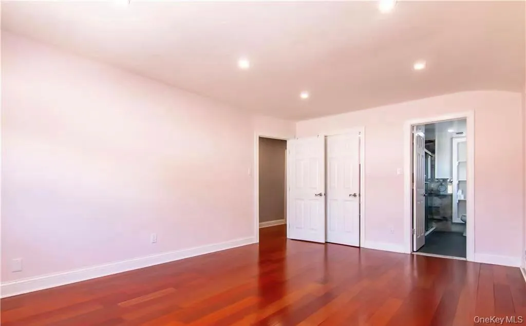 Unfurnished bedroom featuring dark wood-style floors, recessed lighting, and ensuite bath Unfurnished bedroom featuring dark wood-style floors, recessed lighting, and ensuite bath