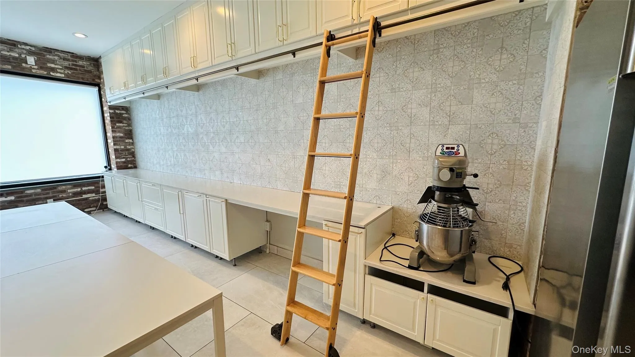 Custom white cabinetry, quartz countertops with library ladder and tile backsplash. Custom white cabinetry, quartz countertops with library ladder and tile backsplash.