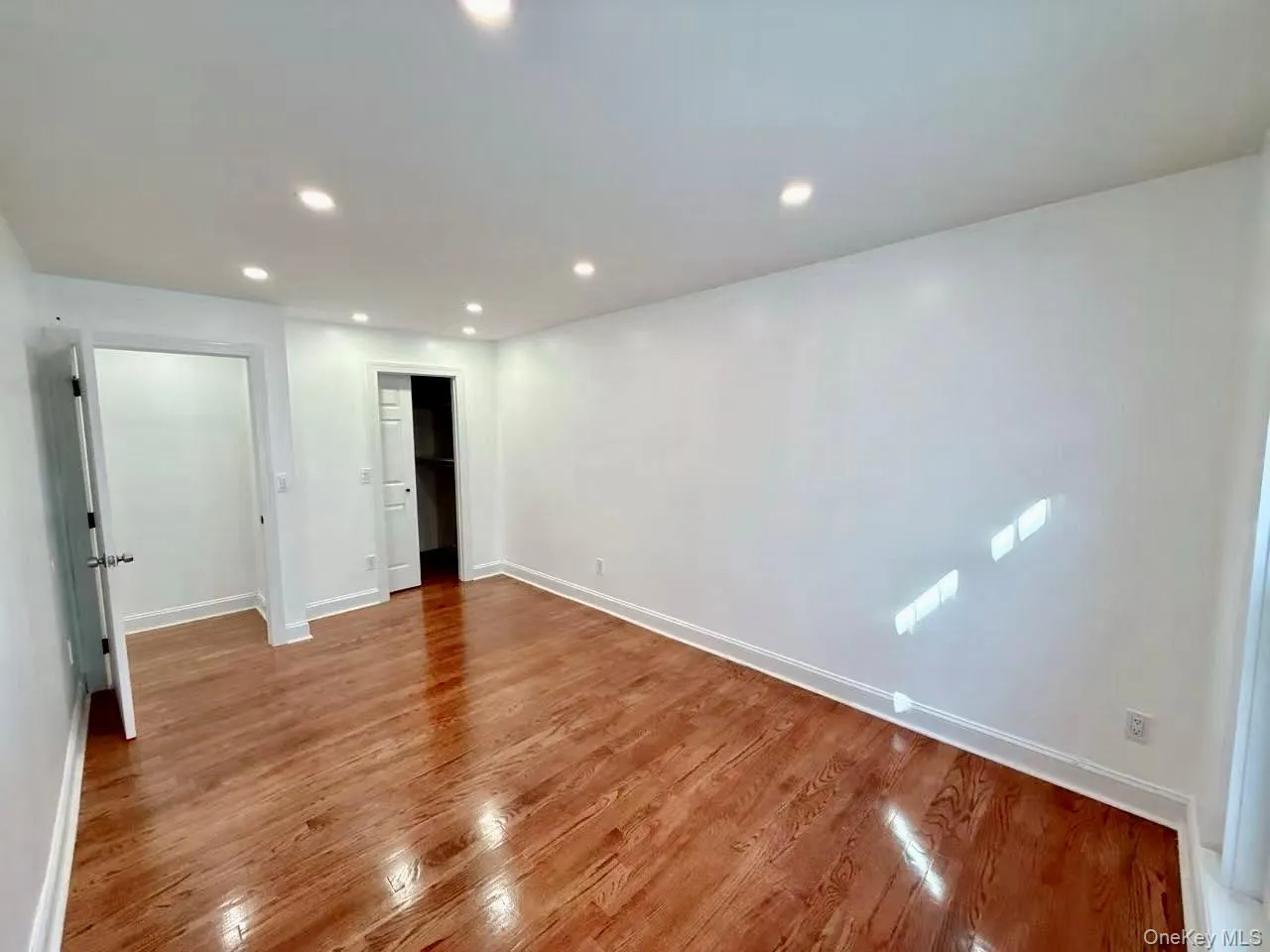 Unfurnished bedroom featuring recessed lighting, wood finished floors, and a spacious closet Unfurnished bedroom featuring recessed lighting, wood finished floors, and a spacious closet