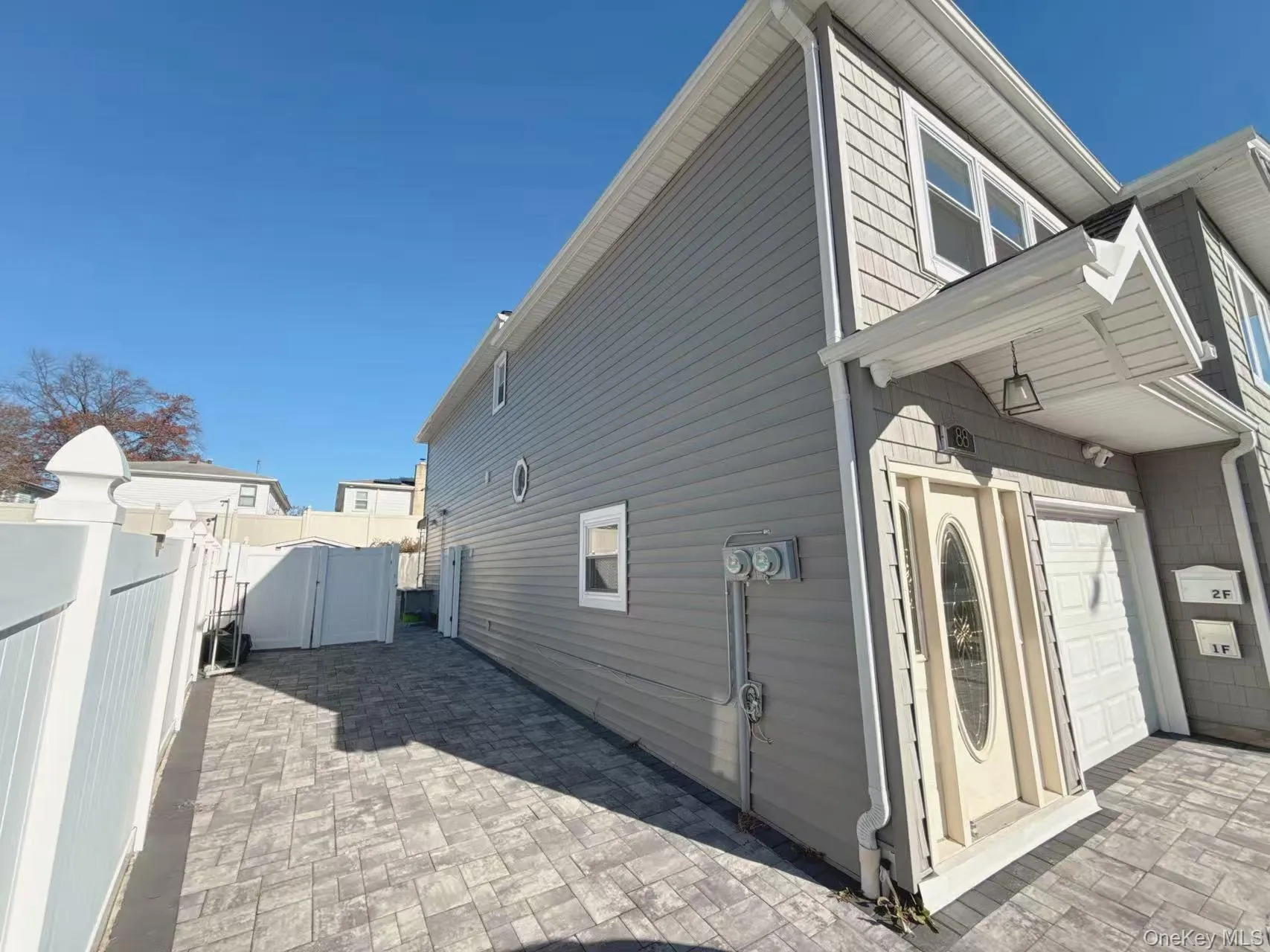 View of property exterior with a gate, a patio area, and an attached garage View of property exterior with a gate, a patio area, and an attached garage