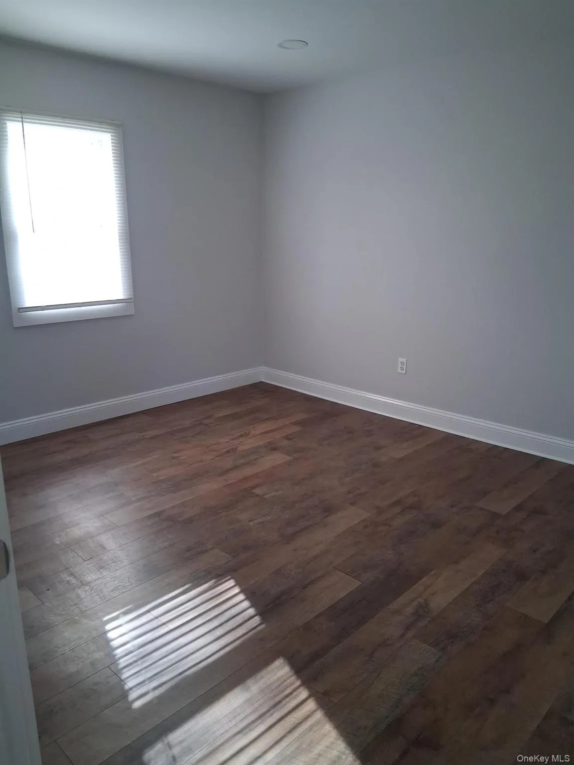 Spare room with dark wood-style flooring Spare room with dark wood-style flooring
