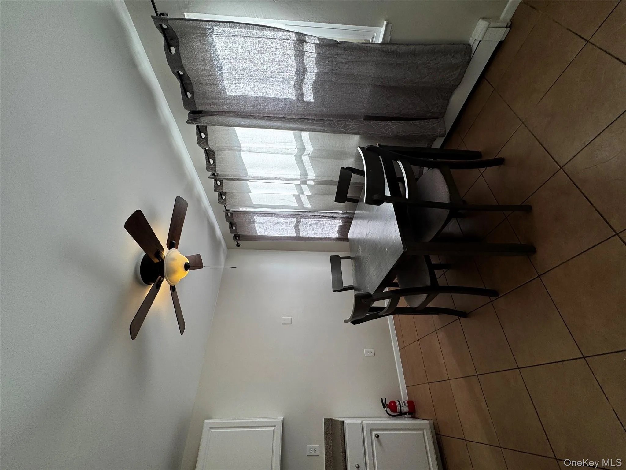 Dining room featuring a baseboard radiator, dark tile patterned flooring, and ceiling fan Dining room featuring a baseboard radiator, dark tile patterned flooring, and ceiling fan