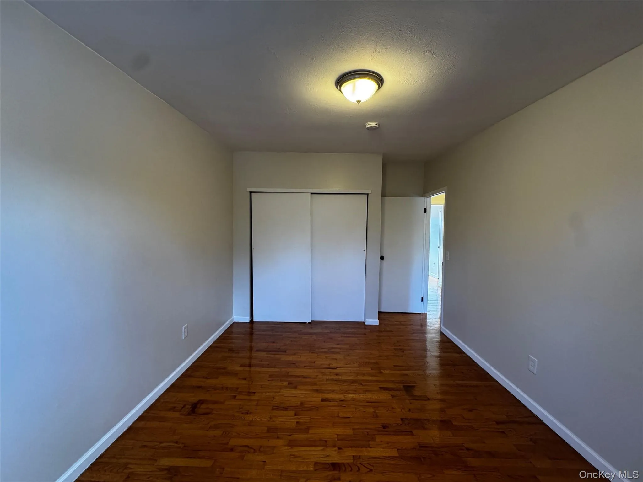 2nd bedroom featuring with wood flooring and full closet 2nd bedroom featuring with wood flooring and full closet