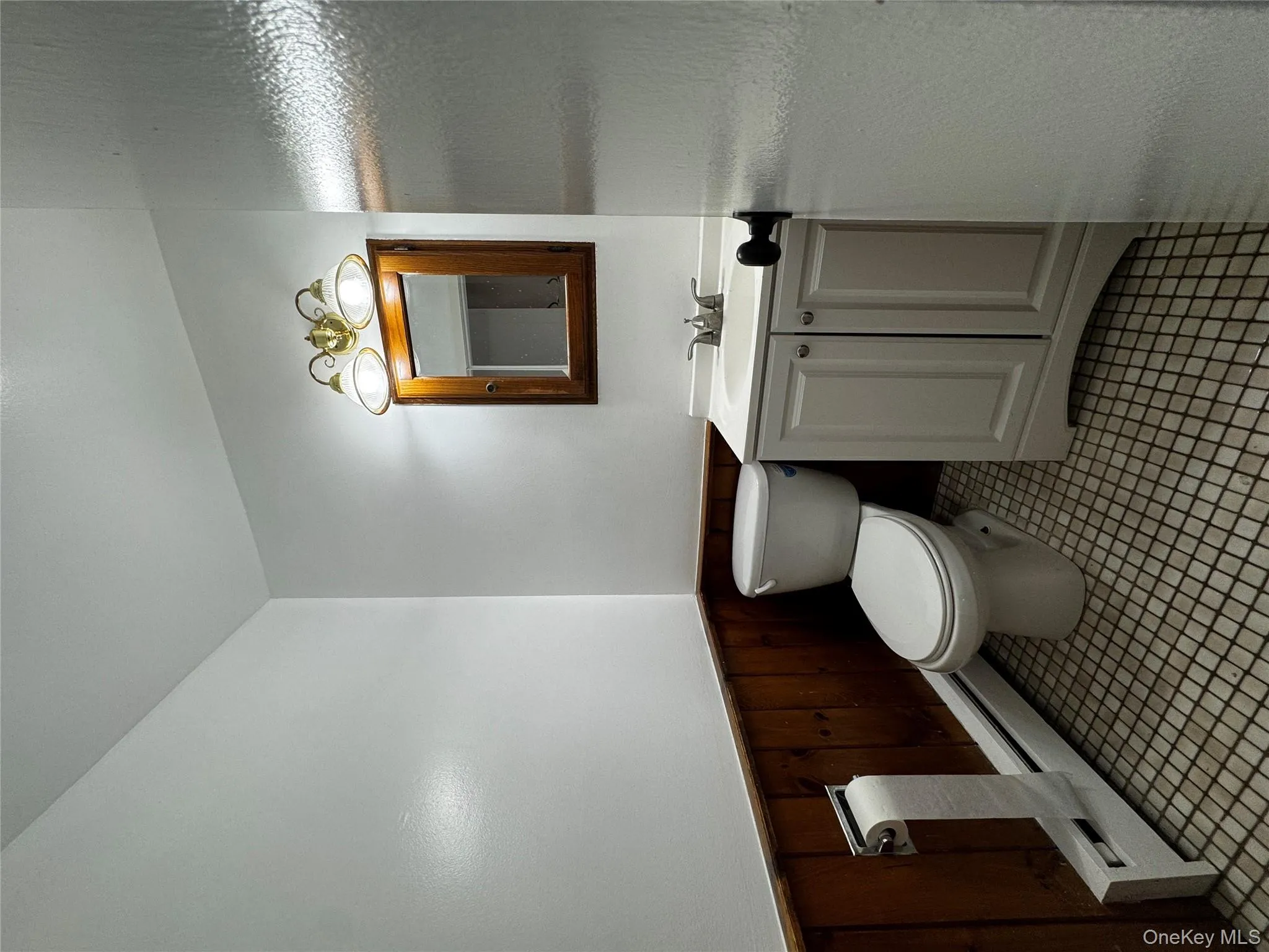 Bathroom featuring a wainscoted wall, vanity, a baseboard radiator, and wood walls Bathroom featuring a wainscoted wall, vanity, a baseboard radiator, and wood walls