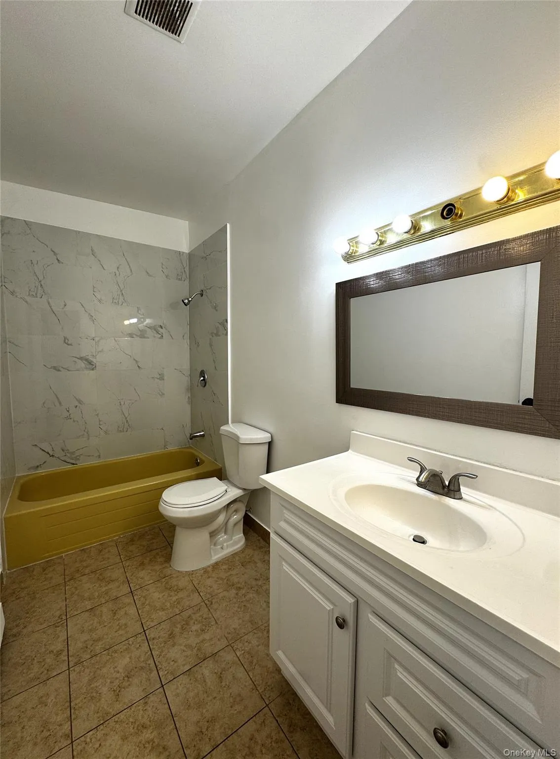 Bathroom featuring shower combination, vanity, and light tile patterned floors Bathroom featuring shower combination, vanity, and light tile patterned floors