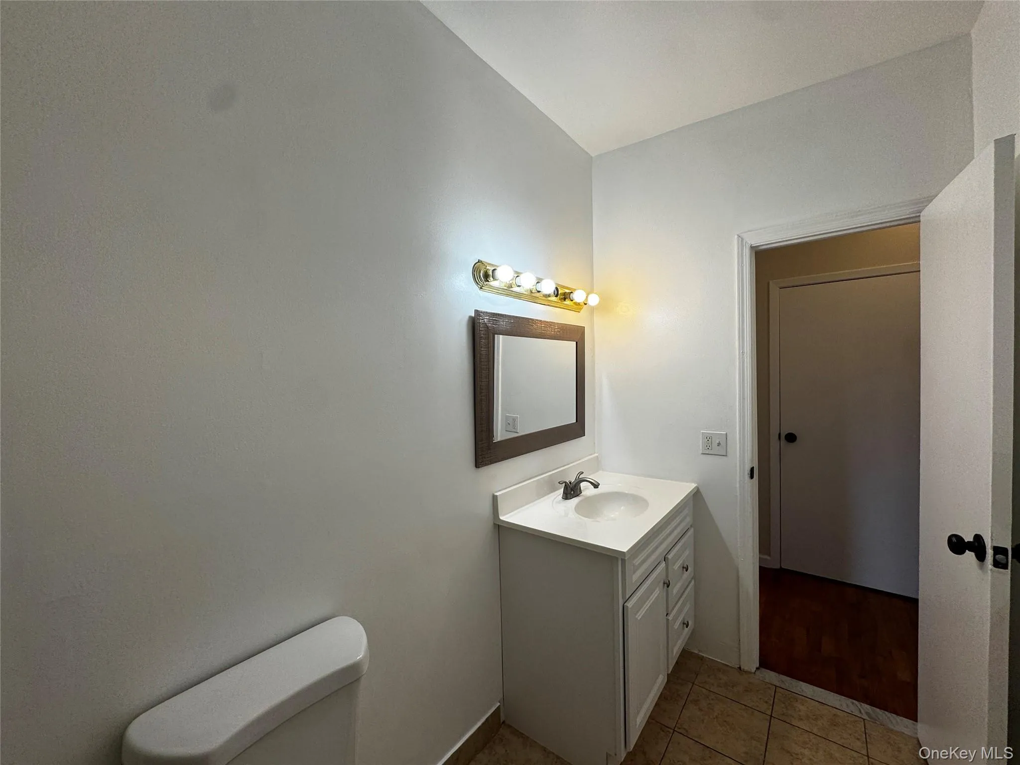Half bath with vanity and light tile patterned floors Half bath with vanity and light tile patterned floors