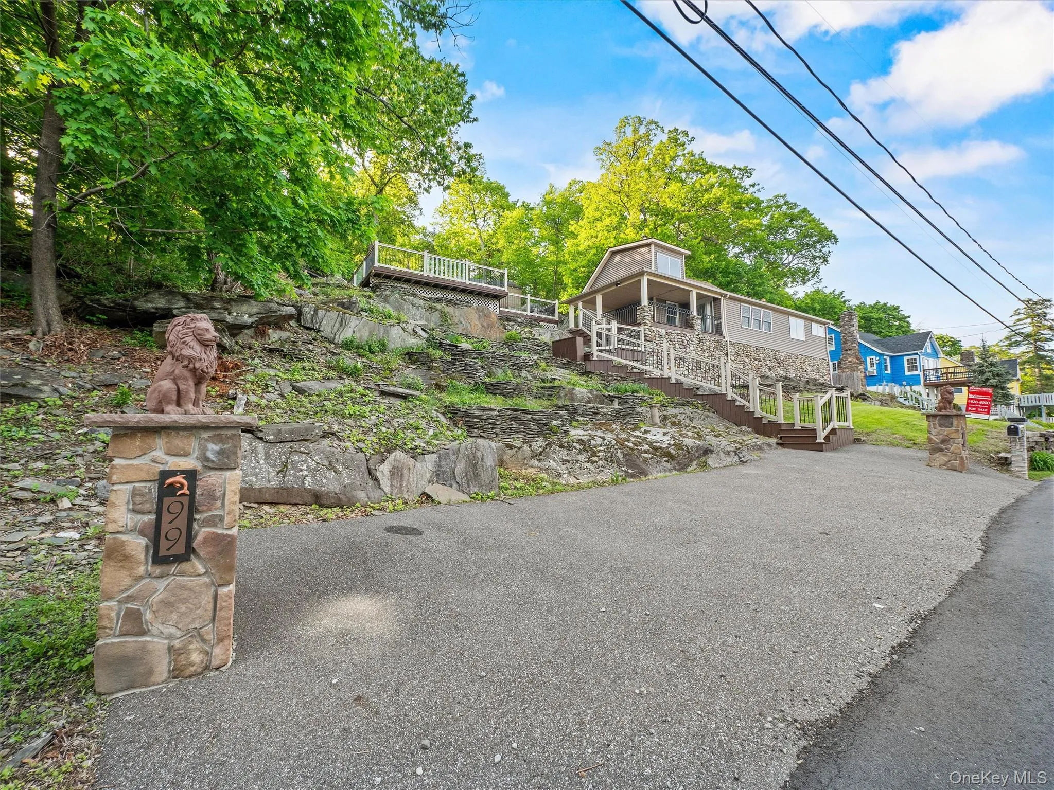 View of front of property featuring stairs and asphalt driveway View of front of property featuring stairs and asphalt driveway