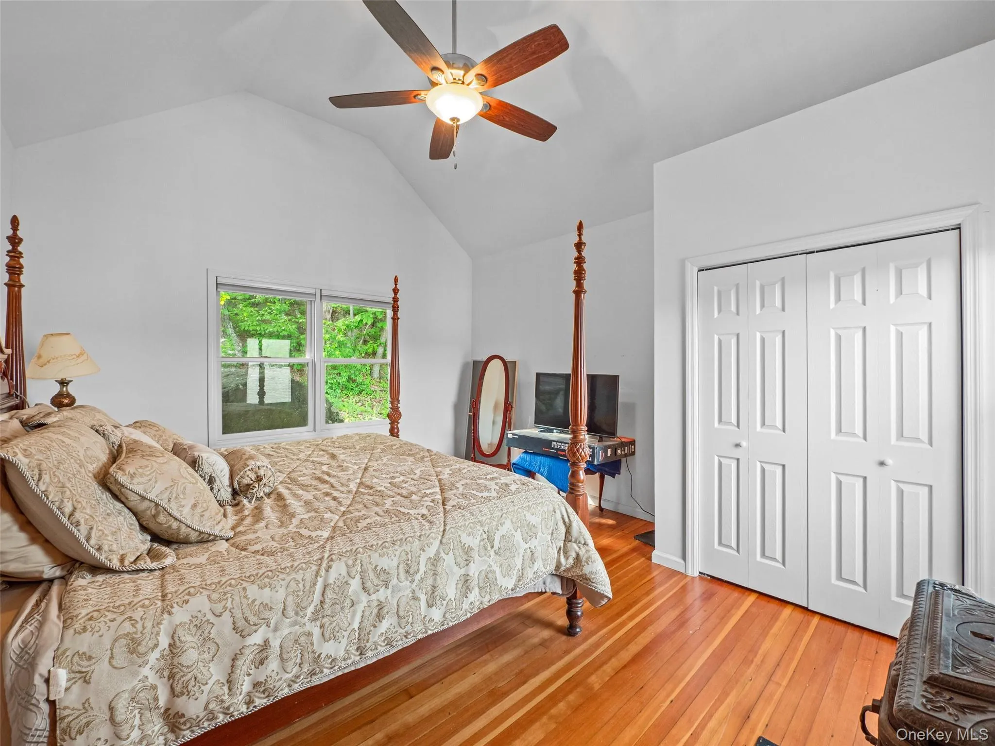 Bedroom featuring a closet, hardwood / wood-style floors, vaulted ceiling, and a ceiling fan Bedroom featuring a closet, hardwood / wood-style floors, vaulted ceiling, and a ceiling fan