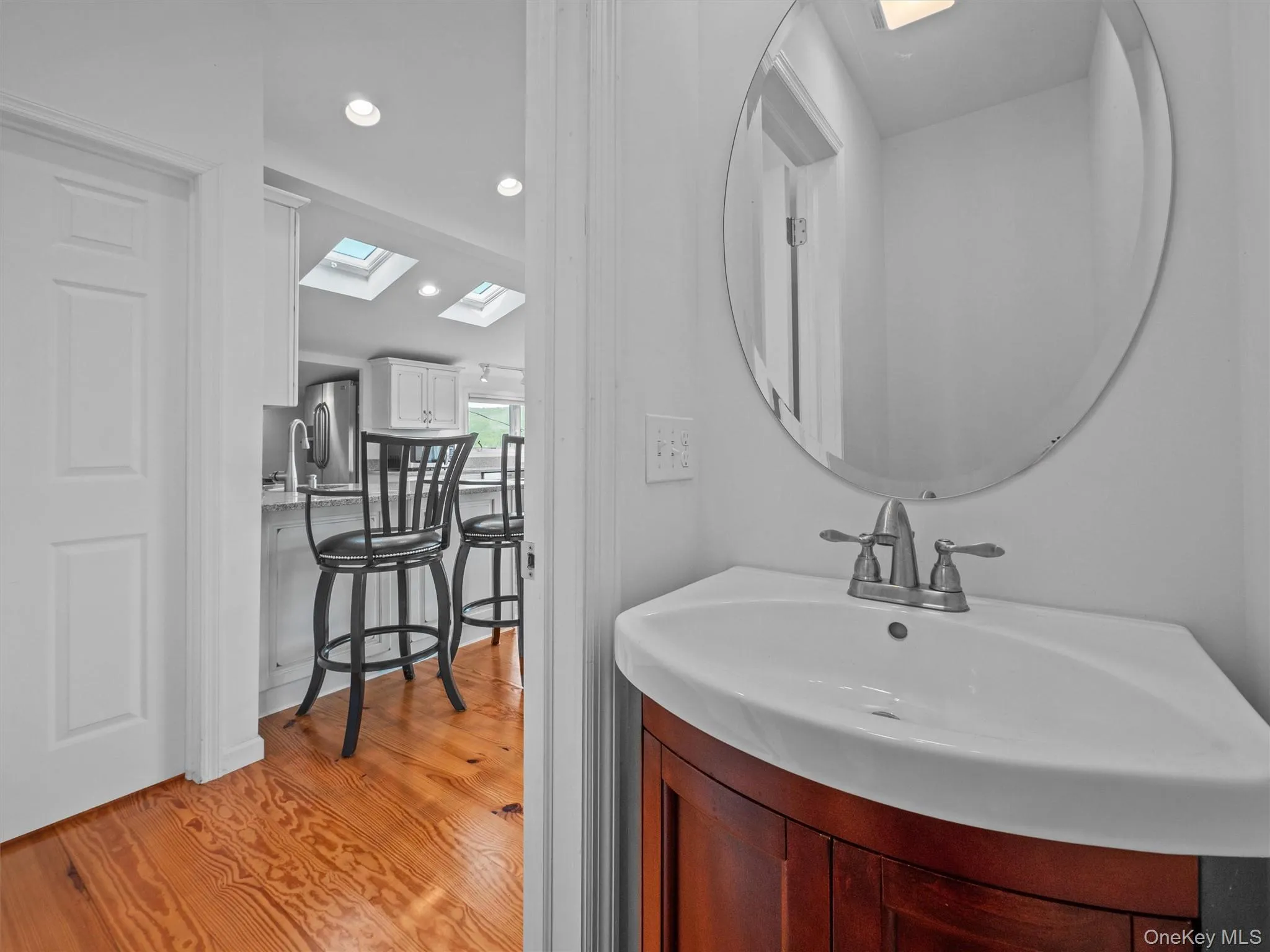 Bathroom with light wood finished floors, vanity, a skylight, and recessed lighting Bathroom with light wood finished floors, vanity, a skylight, and recessed lighting