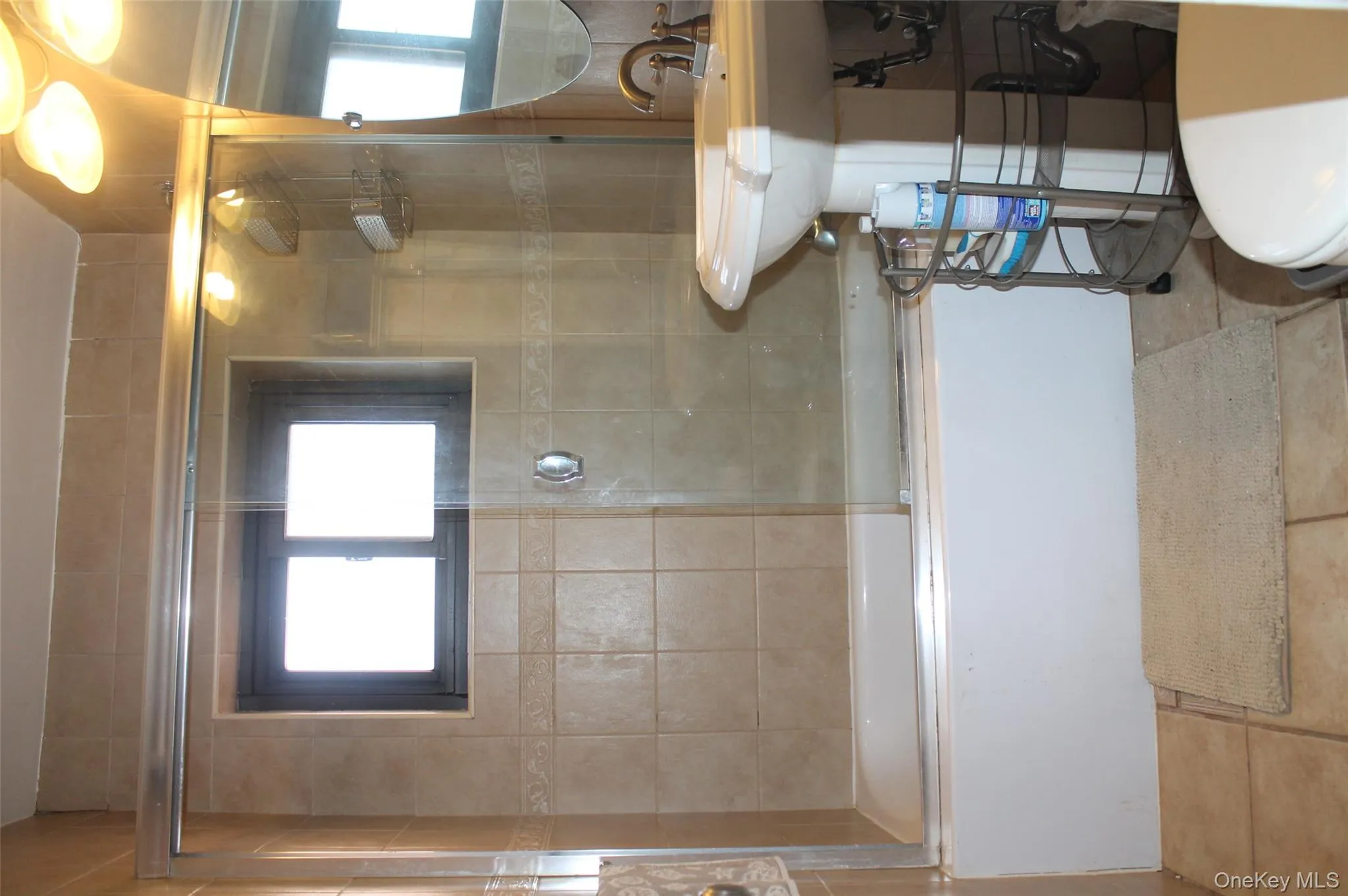 Bathroom with combined bath / shower with glass door, plenty of natural light, and tile patterned flooring Bathroom with combined bath / shower with glass door, plenty of natural light, and tile patterned flooring