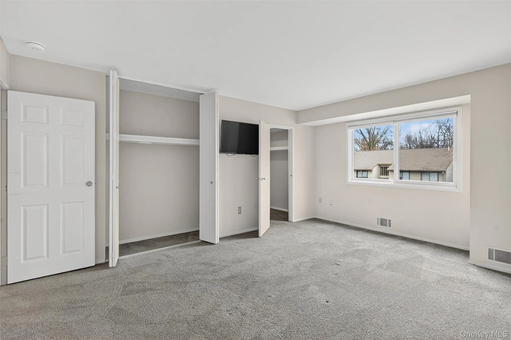 Unfurnished bedroom with carpet flooring and baseboards Unfurnished bedroom with carpet flooring and baseboards