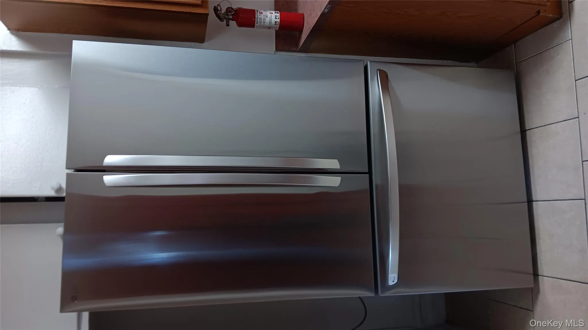 Kitchen view of freestanding refrigerator and a fire extinguisher Kitchen view of freestanding refrigerator and a fire extinguisher