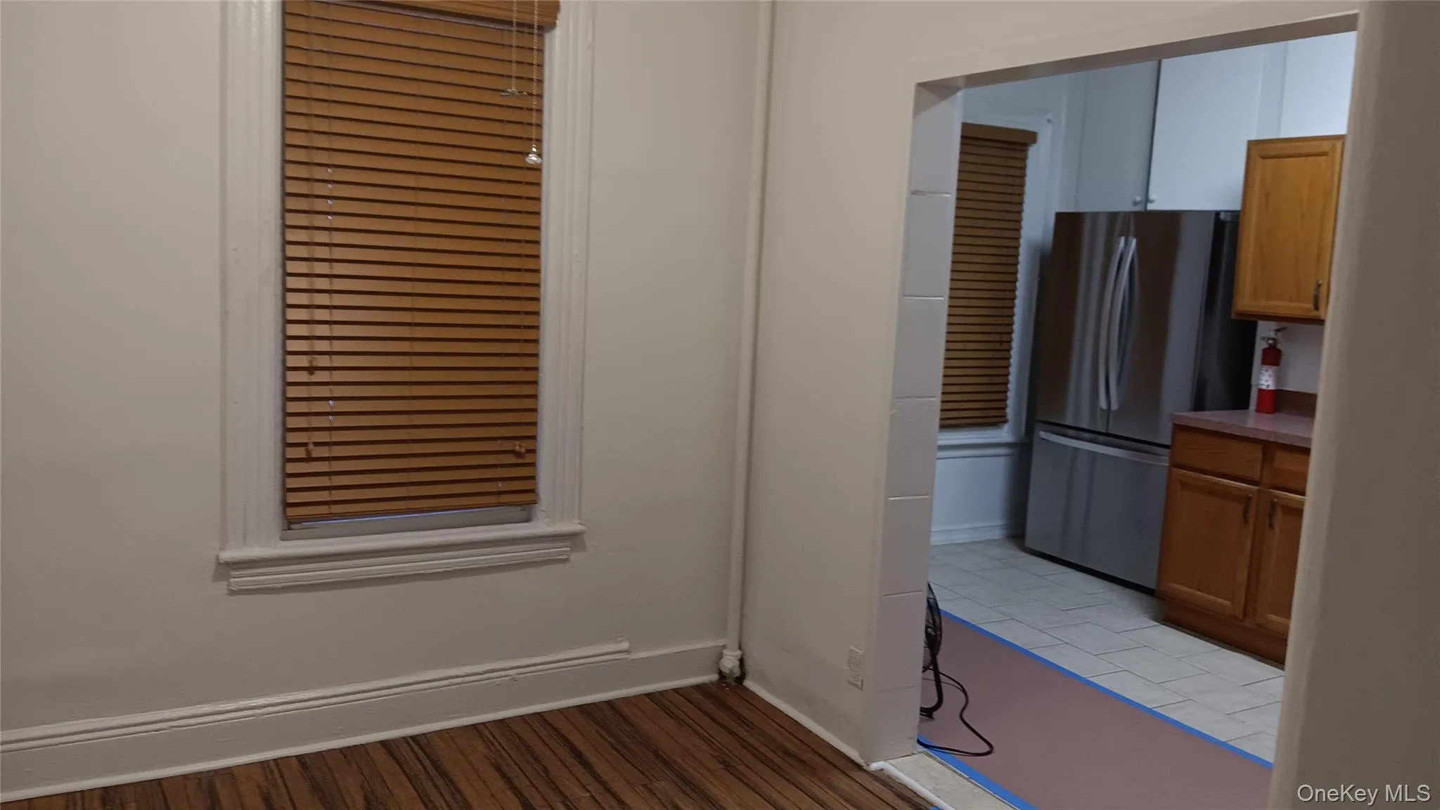 Kitchen with brown cabinetry, freestanding refrigerator, and light wood-type flooring Kitchen with brown cabinetry, freestanding refrigerator, and light wood-type flooring