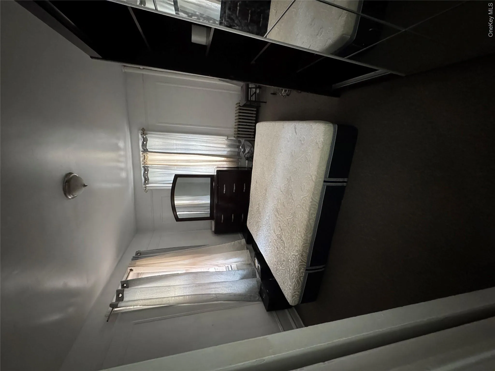 Bedroom featuring radiator heating unit and carpet flooring Bedroom featuring radiator heating unit and carpet flooring