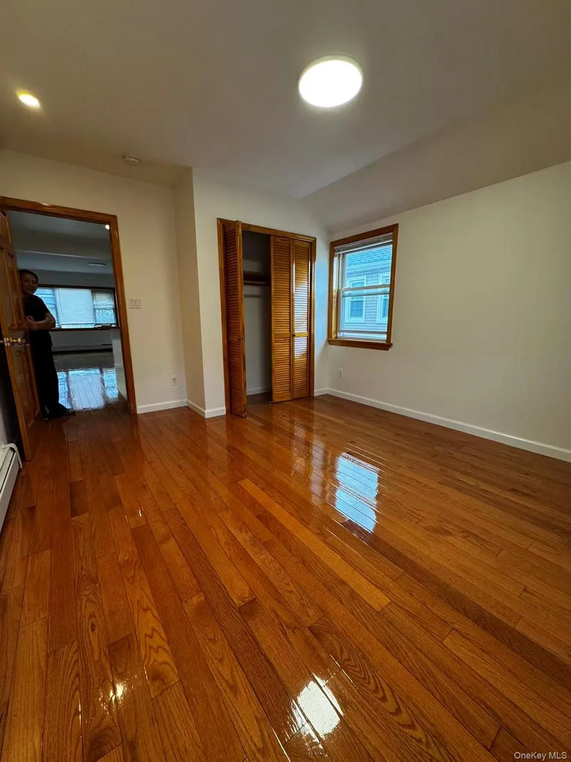 Unfurnished bedroom featuring a closet, hardwood / wood-style floors, and a baseboard radiator Unfurnished bedroom featuring a closet, hardwood / wood-style floors, and a baseboard radiator
