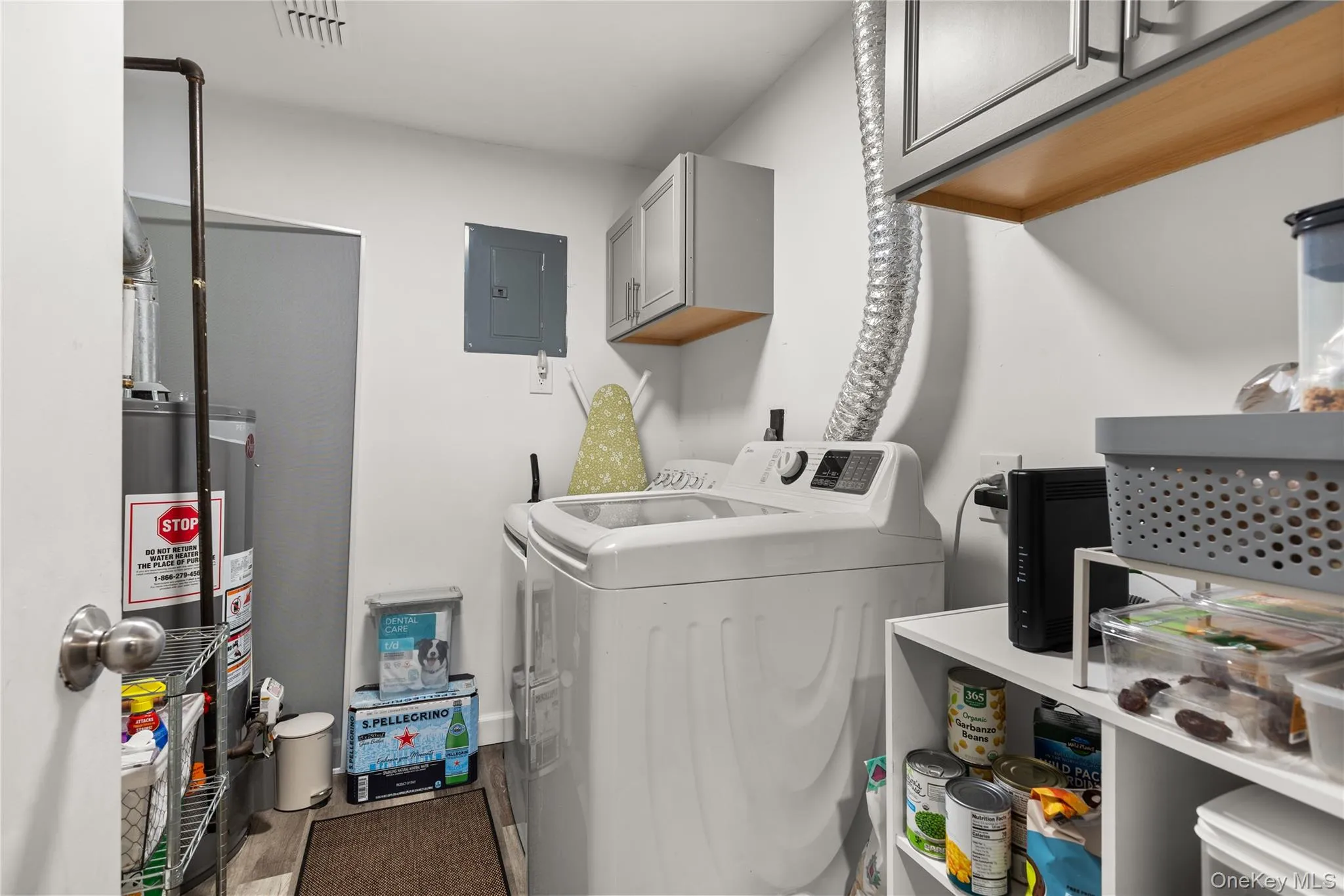 Washroom with electric panel, independent washer and dryer, gas water heater, and cabinet space Washroom with electric panel, independent washer and dryer, gas water heater, and cabinet space