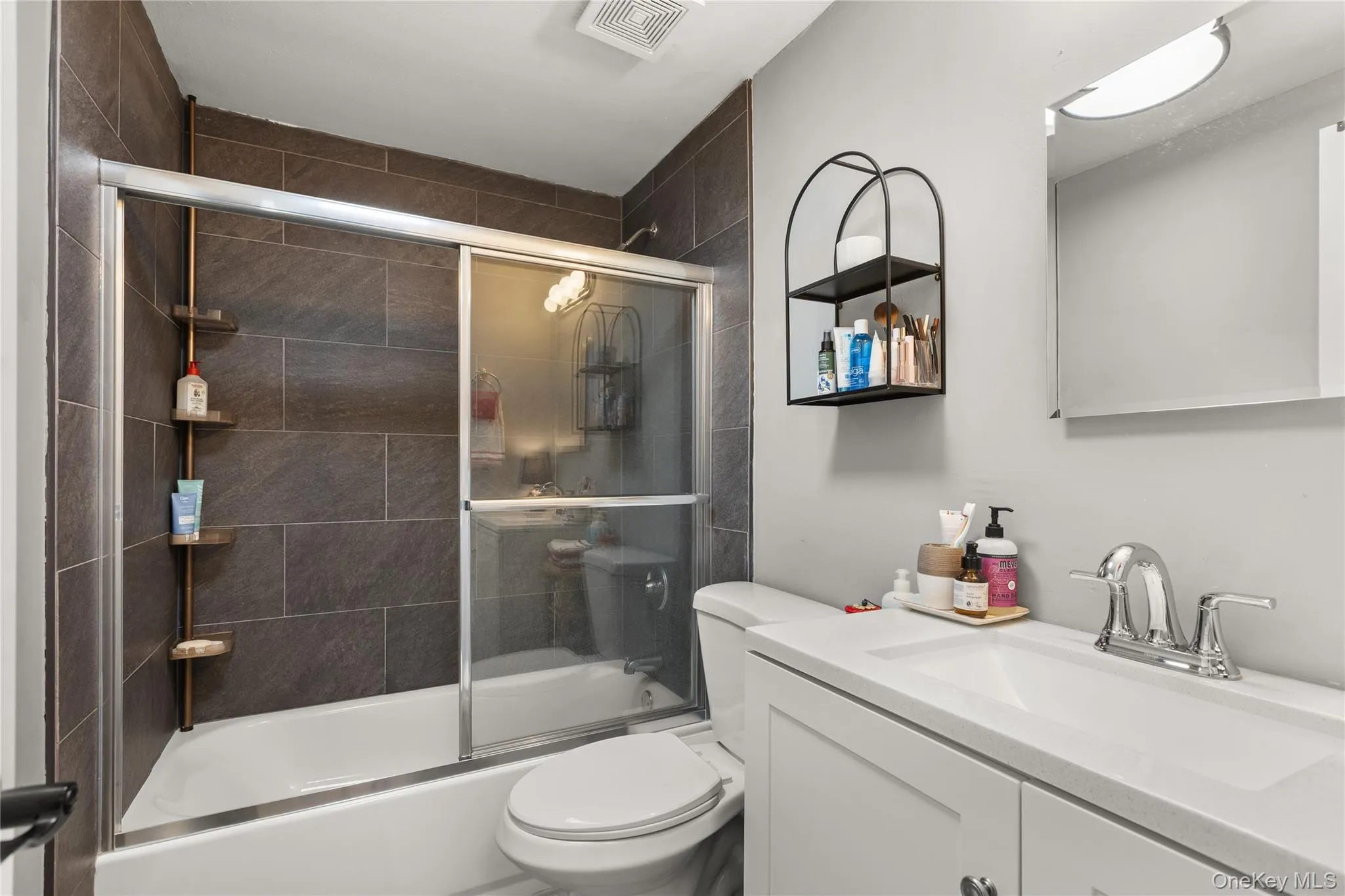 Bathroom featuring enclosed tub / shower combo and vanity Bathroom featuring enclosed tub / shower combo and vanity
