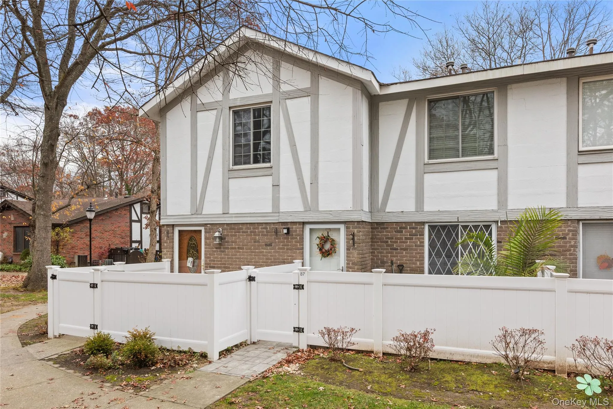 View of side of home featuring brick siding, a fenced front yard, and a gate View of side of home featuring brick siding, a fenced front yard, and a gate