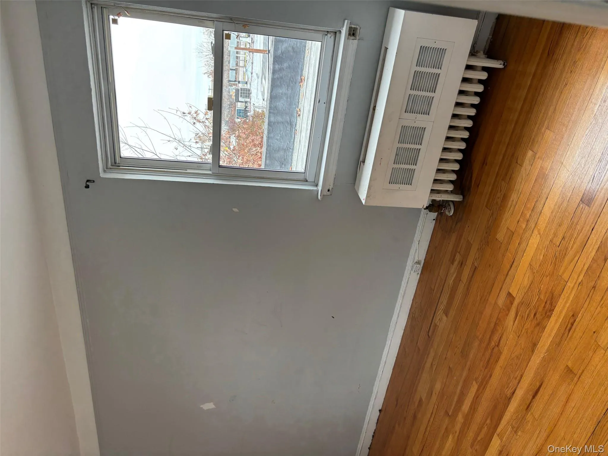 Empty room featuring radiator and light wood-type flooring Empty room featuring radiator and light wood-type flooring
