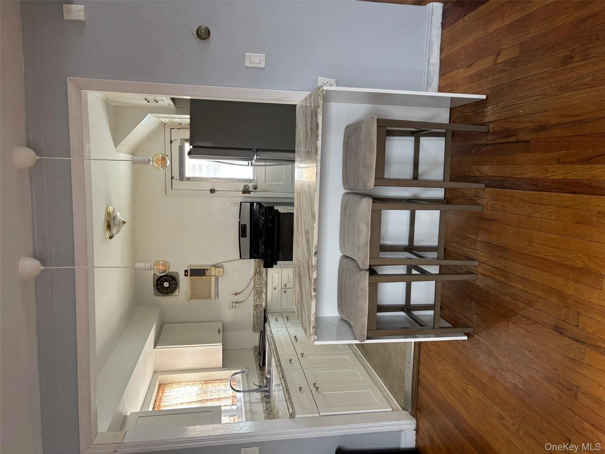 Kitchen with a kitchen bar, a peninsula, white cabinets, pendant lighting, and refrigerator Kitchen with a kitchen bar, a peninsula, white cabinets, pendant lighting, and refrigerator