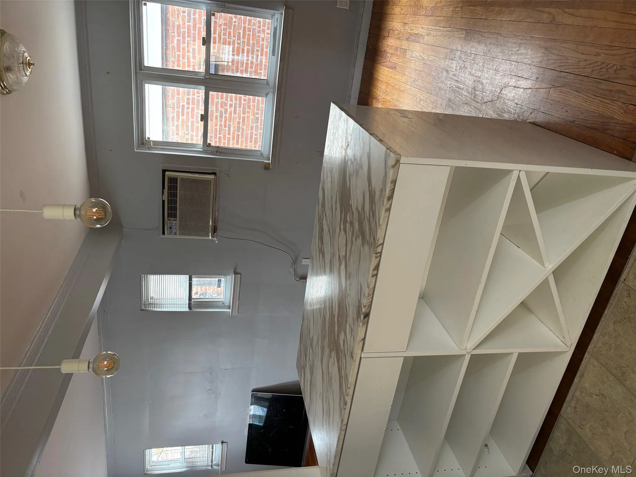 Kitchen with hanging light fixtures, ornamental molding, white cabinetry, and a wall unit AC Kitchen with hanging light fixtures, ornamental molding, white cabinetry, and a wall unit AC
