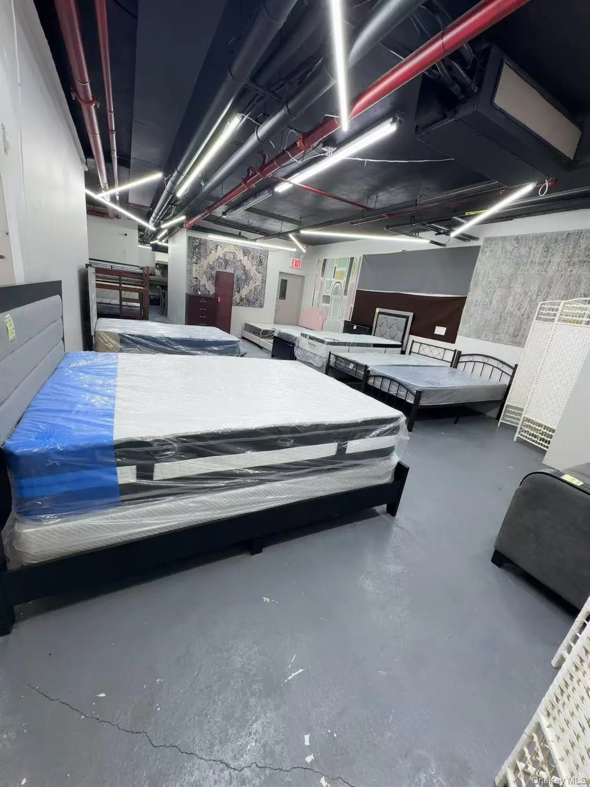 Bedroom with finished concrete flooring and wallpapered walls Bedroom with finished concrete flooring and wallpapered walls