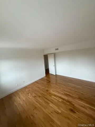 Spare room with baseboards and wood finished floors Spare room with baseboards and wood finished floors