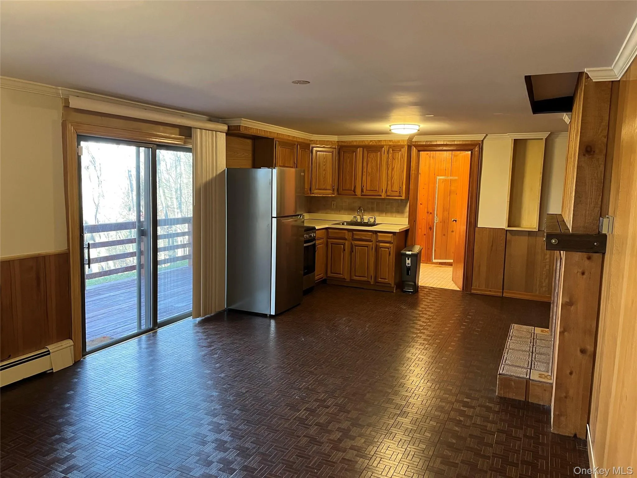 Living room with wainscoting, wooden walls, sliding glass door to deck Living room with wainscoting, wooden walls, sliding glass door to deck