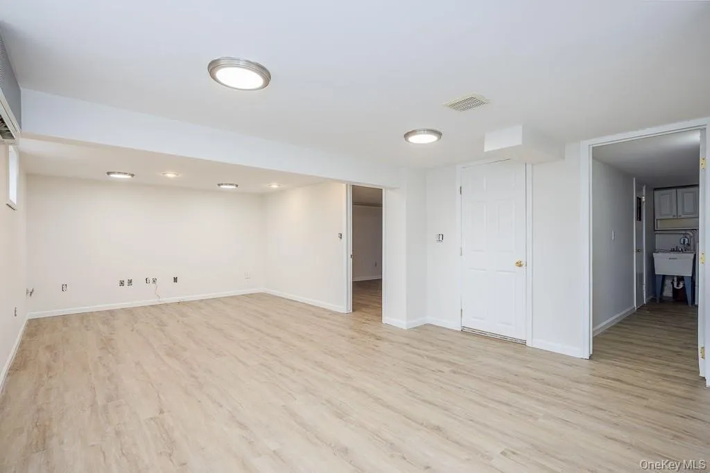 Finished below grade area featuring light wood finished floors and baseboards Finished below grade area featuring light wood finished floors and baseboards