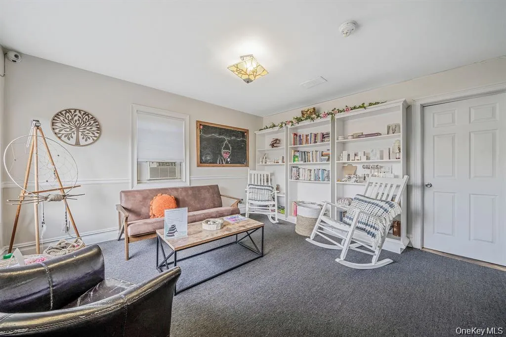 Sitting room with carpet flooring and cooling unit Sitting room with carpet flooring and cooling unit