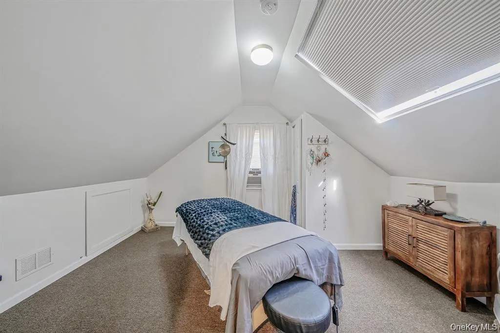 Bedroom with lofted ceiling and carpet flooring Bedroom with lofted ceiling and carpet flooring