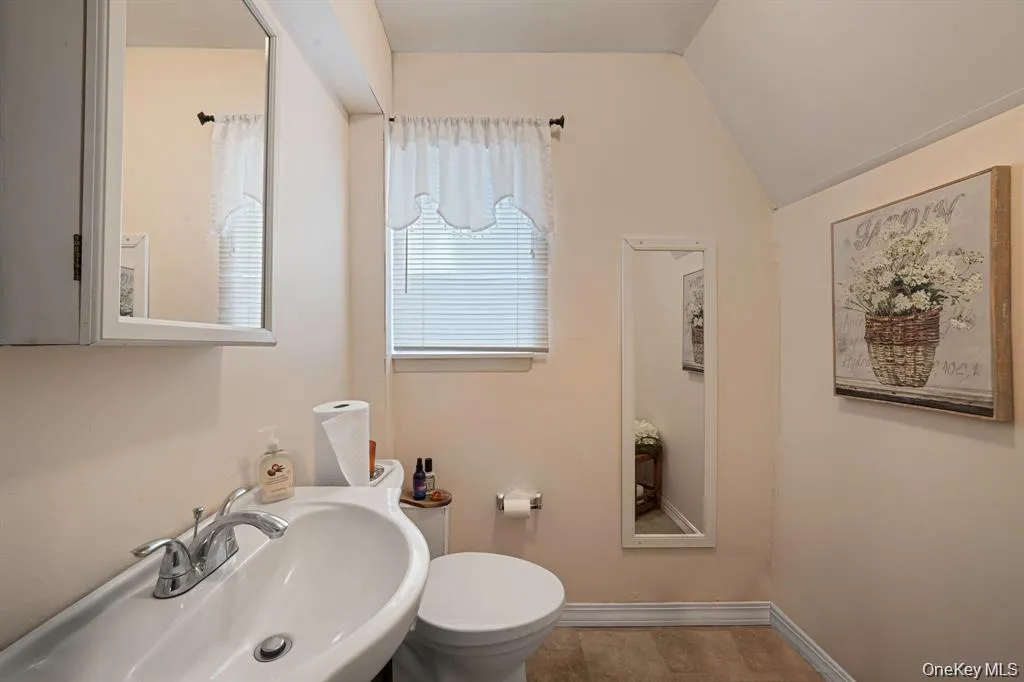 Bathroom featuring toilet and lofted ceiling Bathroom featuring toilet and lofted ceiling