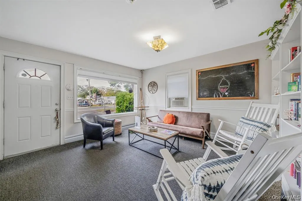 Living area featuring carpet floors and cooling unit Living area featuring carpet floors and cooling unit