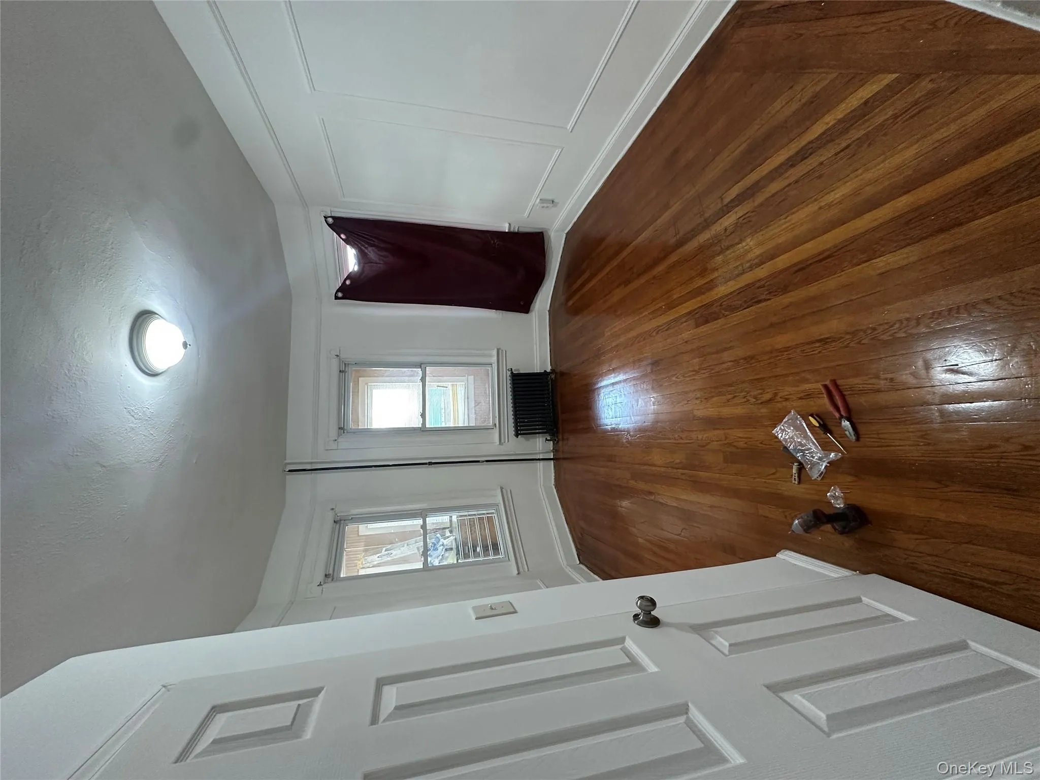 Spare room with a decorative wall, dark wood-type flooring, a textured ceiling, and radiator Spare room with a decorative wall, dark wood-type flooring, a textured ceiling, and radiator