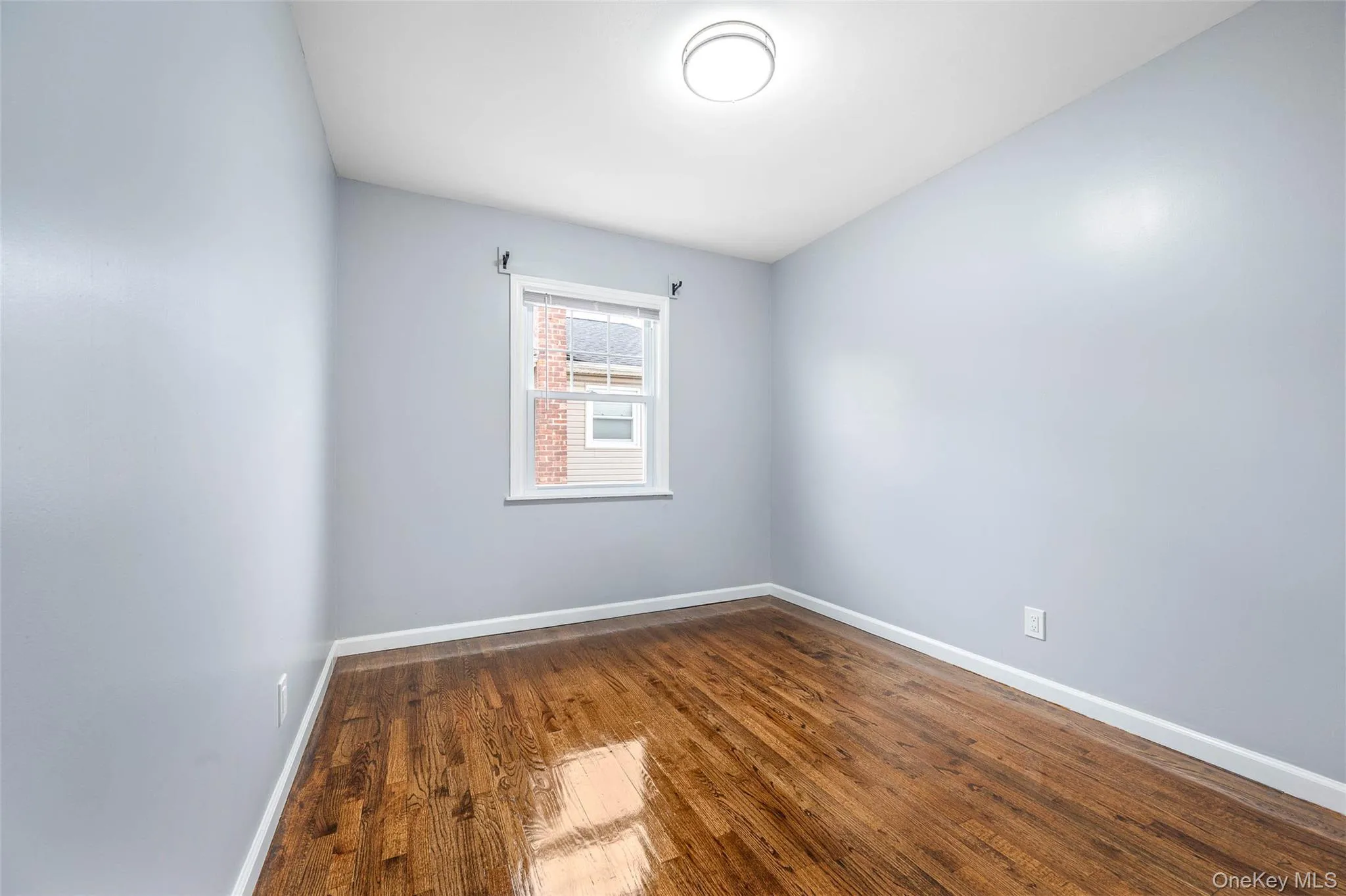 Empty room featuring dark wood-style floors and baseboards Empty room featuring dark wood-style floors and baseboards