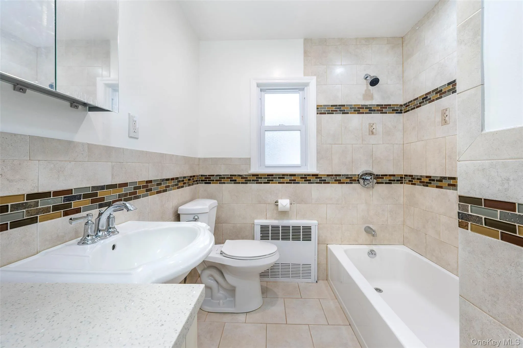 Bathroom with shower / tub combination, radiator, tile walls, vanity, and light tile patterned flooring Bathroom with shower / tub combination, radiator, tile walls, vanity, and light tile patterned flooring