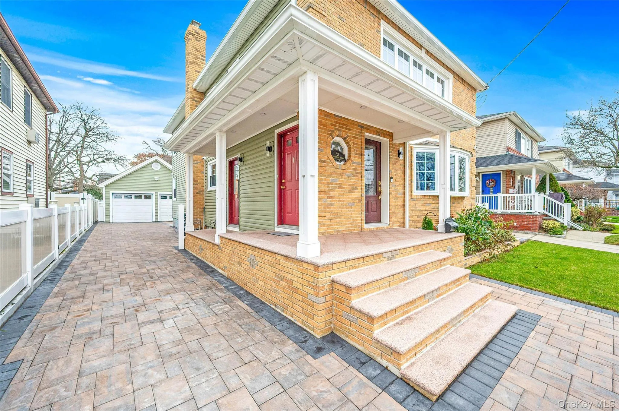 View of front of property featuring a porch, brick siding, a garage, and a chimney View of front of property featuring a porch, brick siding, a garage, and a chimney