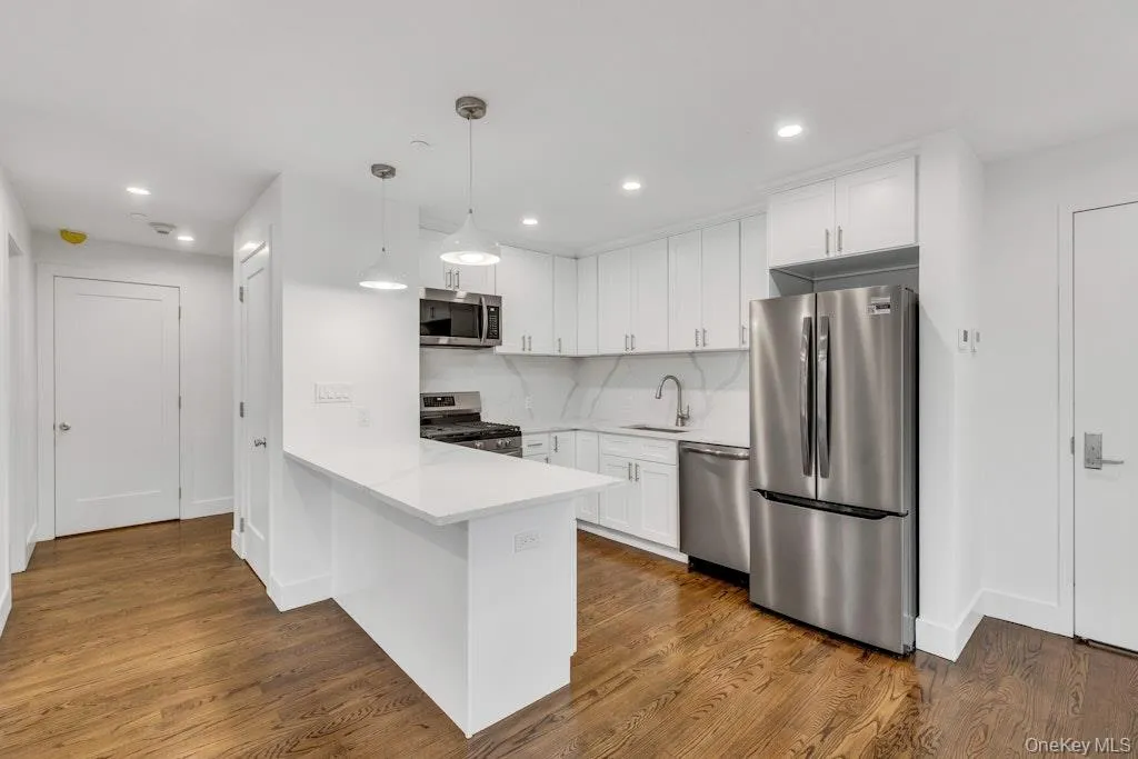 Kitchen with stainless steel appliances, white cabinetry, and a peninsula Kitchen with stainless steel appliances, white cabinetry, and a peninsula