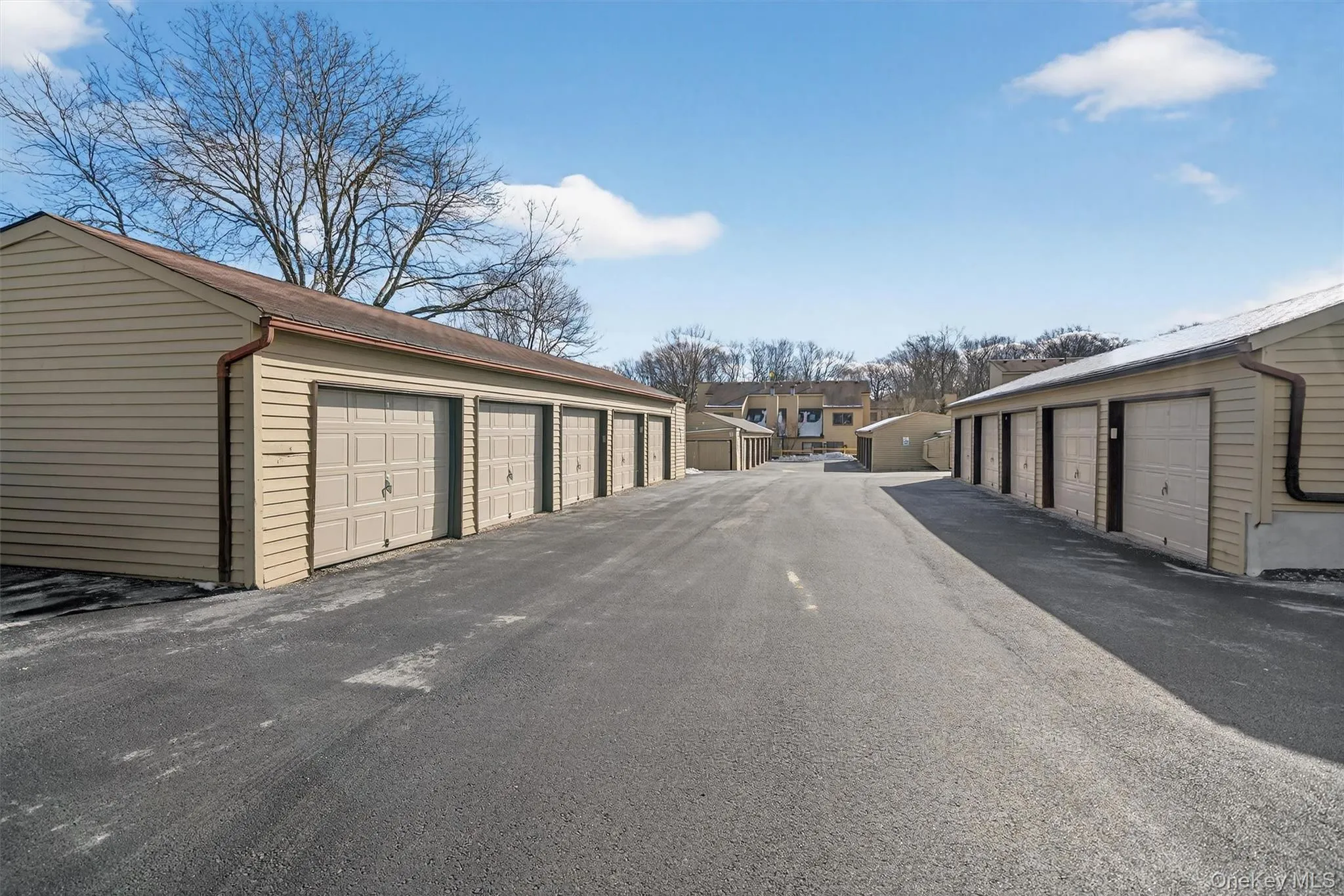 View of asphalt alley with community garages and a residential view View of asphalt alley with community garages and a residential view