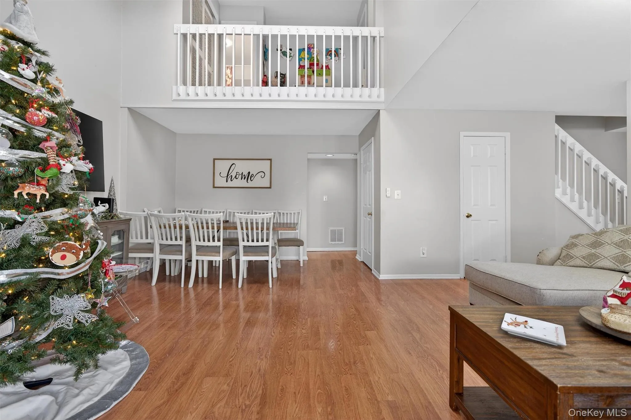Living area with wood finished floors, stairway, and a towering ceiling Living area with wood finished floors, stairway, and a towering ceiling