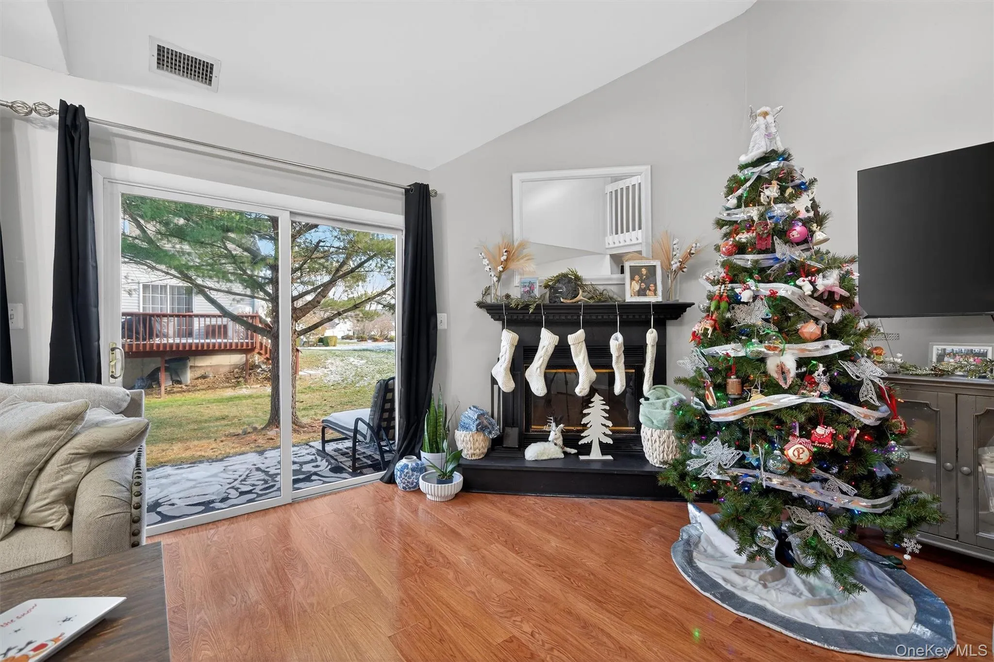 Living area with wood finished floors and lofted ceiling Living area with wood finished floors and lofted ceiling