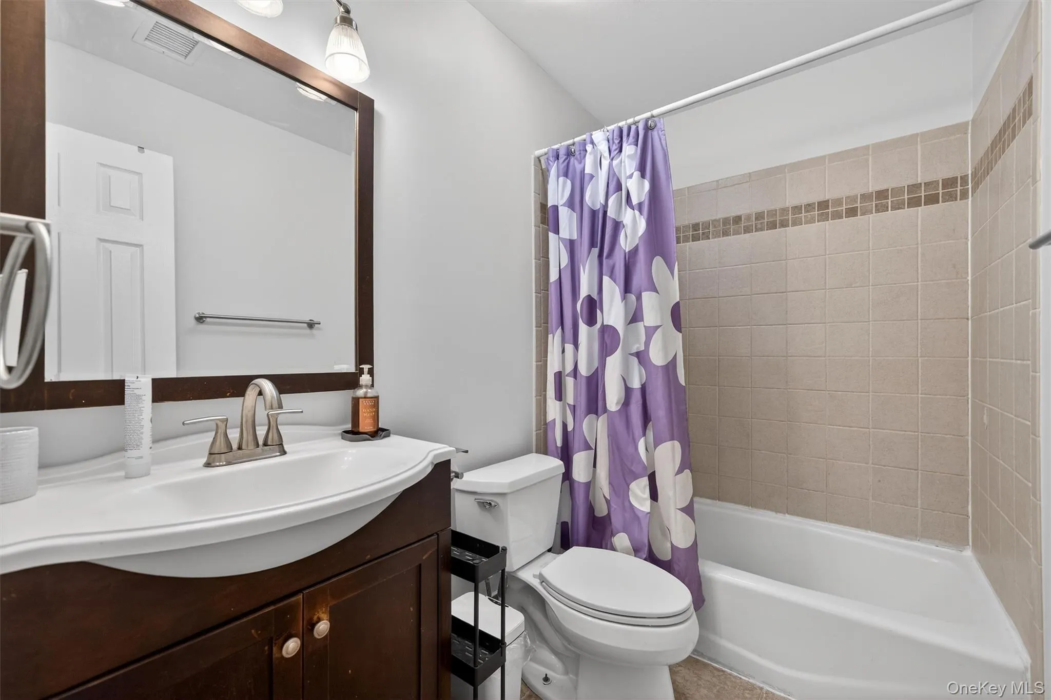 Bathroom featuring vanity and shower / tub combo Bathroom featuring vanity and shower / tub combo
